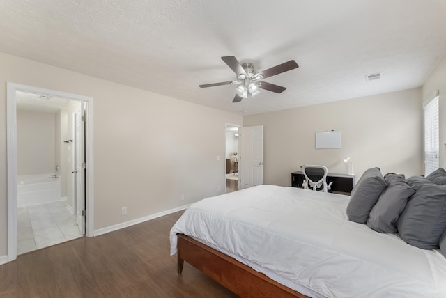 bedroom with visible vents, a textured ceiling, wood finished floors, connected bathroom, and baseboards