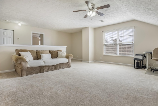 living area featuring carpet flooring, visible vents, a textured ceiling, and ceiling fan