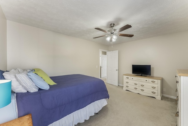 bedroom featuring light colored carpet, a textured ceiling, and ceiling fan