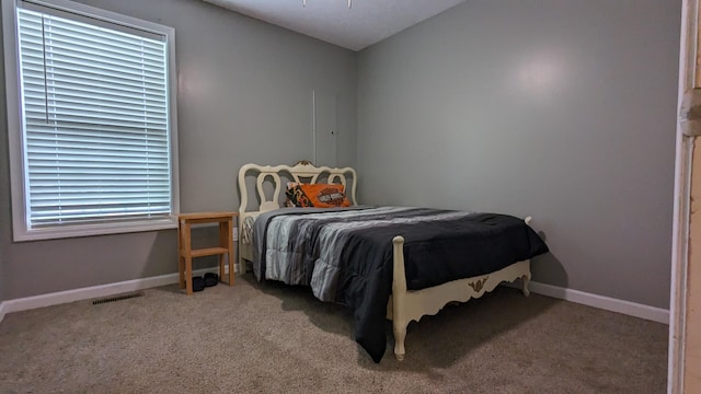 carpeted bedroom featuring baseboards and visible vents