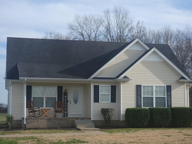 view of front of property featuring covered porch and roof with shingles