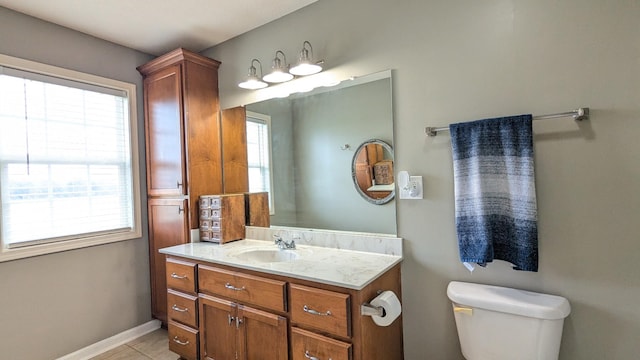 bathroom with vanity, tile patterned floors, toilet, and baseboards