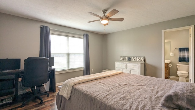 bedroom with connected bathroom, dark wood-style floors, baseboards, and a textured ceiling