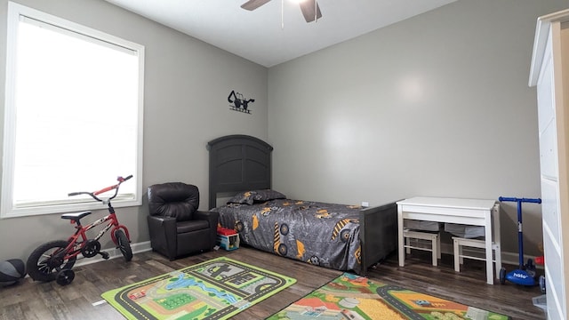 bedroom featuring a ceiling fan, wood finished floors, and baseboards