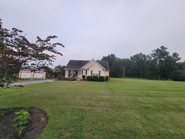 view of front of property featuring a front yard and a detached garage