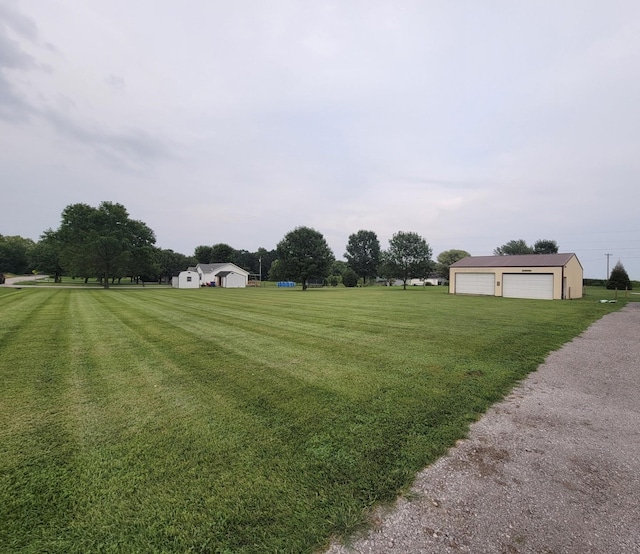 view of yard with a detached garage and an outdoor structure