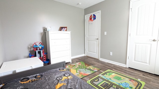 bedroom with wood finished floors and baseboards