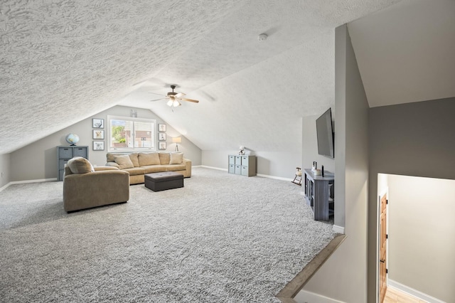 carpeted living room with a textured ceiling, lofted ceiling, baseboards, and a ceiling fan