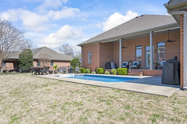 view of pool featuring fence, area for grilling, a patio, a fenced in pool, and a lawn