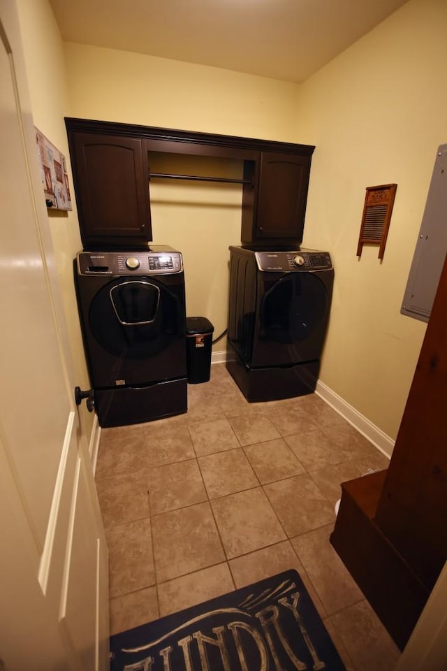 clothes washing area with baseboards, light tile patterned floors, electric panel, cabinet space, and independent washer and dryer