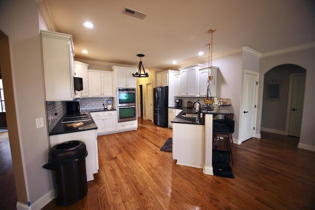 kitchen with visible vents, dark countertops, appliances with stainless steel finishes, and crown molding