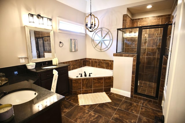 bathroom featuring a shower stall, a garden tub, an inviting chandelier, tile patterned floors, and vanity