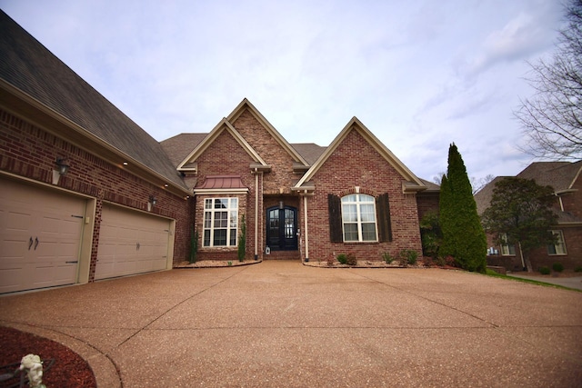 view of front of home with a garage, brick siding, and concrete driveway