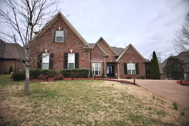 traditional home with brick siding and a front lawn