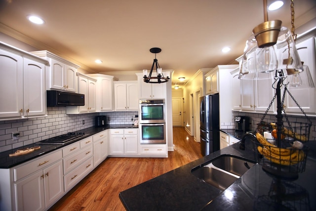 kitchen with a sink, black appliances, light wood-style floors, white cabinetry, and exhaust hood