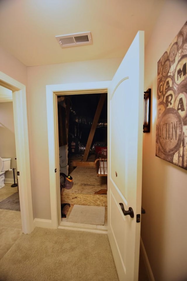 hallway with visible vents, carpet flooring, and baseboards