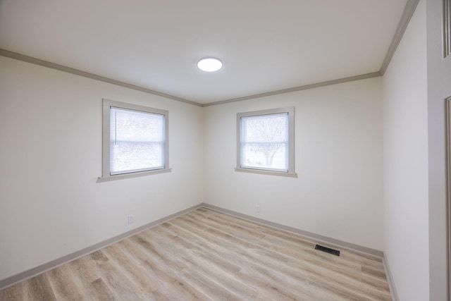 unfurnished room featuring crown molding, baseboards, visible vents, and light wood finished floors