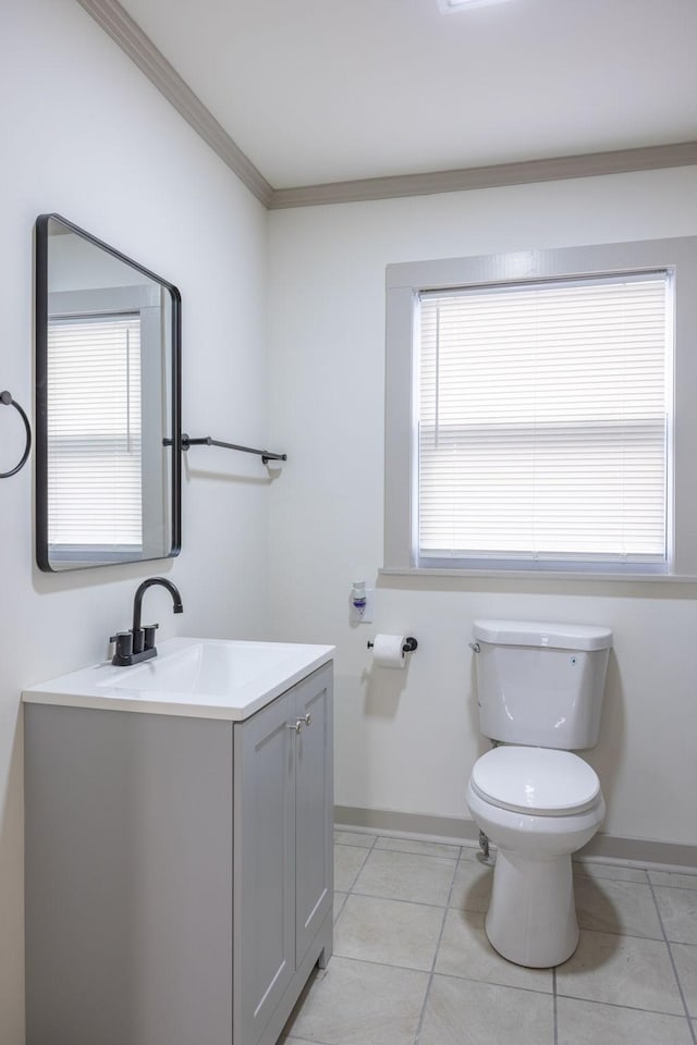 bathroom with vanity, baseboards, ornamental molding, tile patterned floors, and toilet