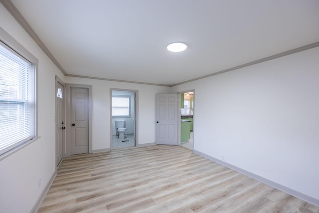 unfurnished room with baseboards, crown molding, and light wood finished floors
