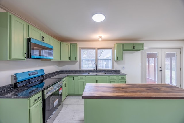 kitchen with stainless steel electric range and green cabinets