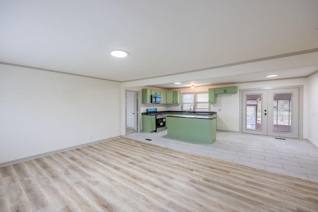 kitchen featuring crown molding, green cabinets, french doors, stainless steel appliances, and a sink