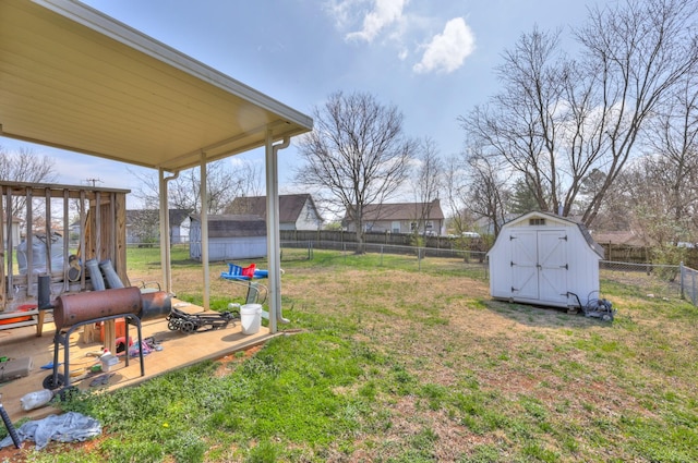 view of yard featuring an outbuilding, a shed, and a fenced backyard