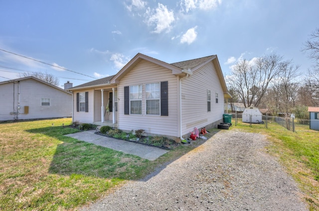 bungalow with driveway, a front lawn, and fence