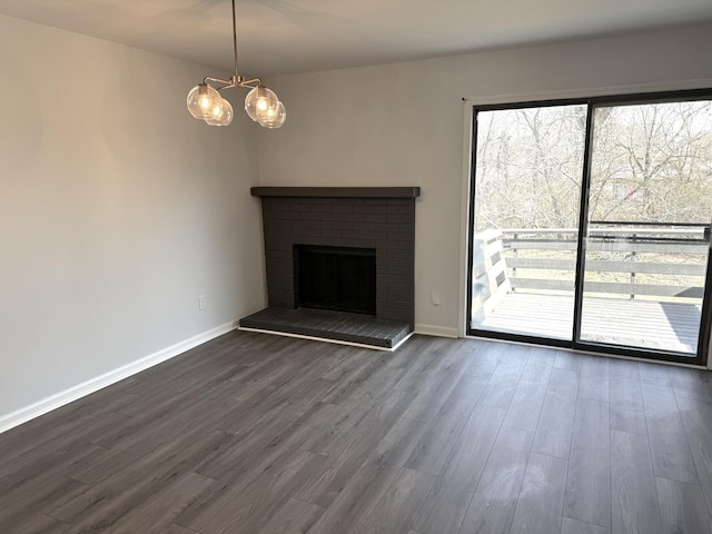 1239 N Graycroft Ave, Madison, TN 37115 - unfurnished living room with a brick fireplace, baseboards, an inviting chandelier, and dark wood-style floors