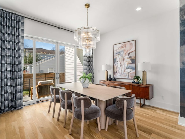 dining area with baseboards, recessed lighting, light wood finished floors, and a chandelier