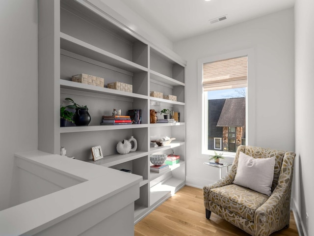 living area featuring visible vents and light wood finished floors