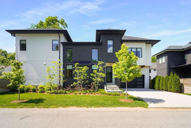 modern home featuring an attached garage, driveway, and a front yard