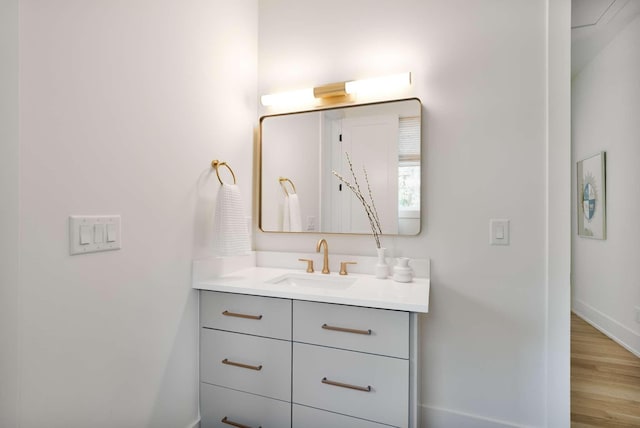 bathroom featuring baseboards, wood finished floors, and vanity