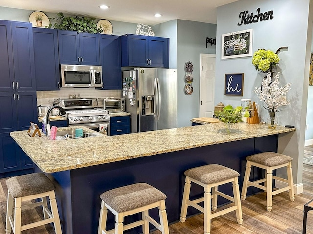 670 Jones Franklin Rd, Morristown, TN 37813 - kitchen with appliances with stainless steel finishes, blue cabinetry, a kitchen breakfast bar, a sink, and recessed lighting
