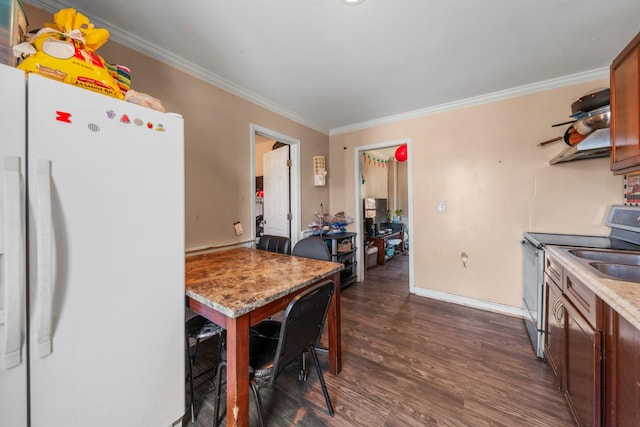 kitchen with crown molding, baseboards, stainless steel electric stove, freestanding refrigerator, and dark wood-style flooring