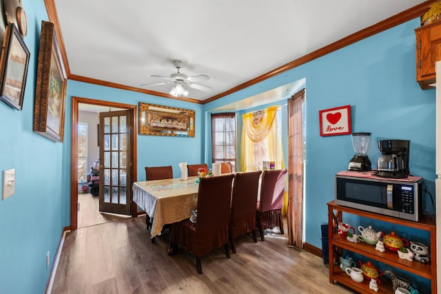 dining room with plenty of natural light, crown molding, and wood finished floors