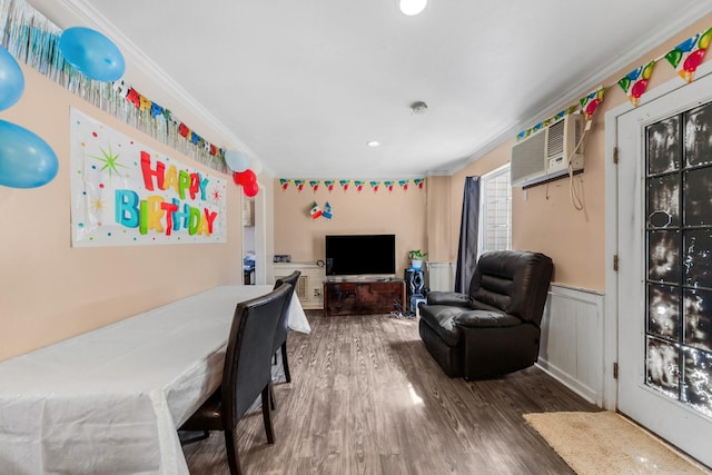 interior space featuring a wainscoted wall, wood finished floors, ornamental molding, and a wall unit AC