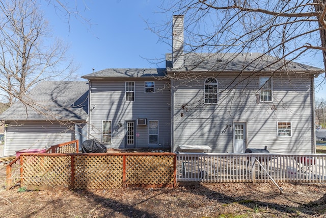 back of house with a wooden deck and a chimney