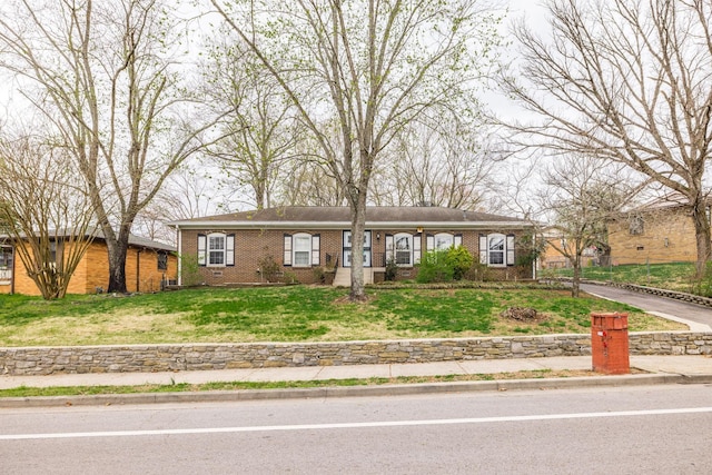 single story home featuring a front yard and brick siding