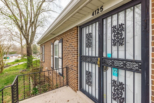 doorway to property featuring brick siding