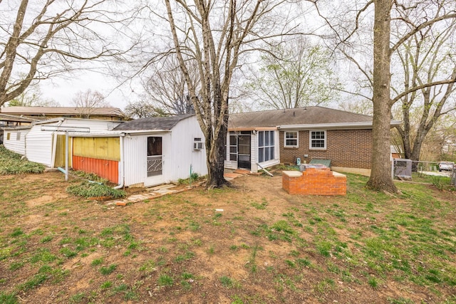back of property featuring an outbuilding, brick siding, and fence