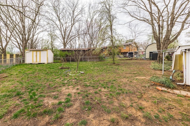 view of yard with an outdoor structure, a storage unit, and a fenced backyard