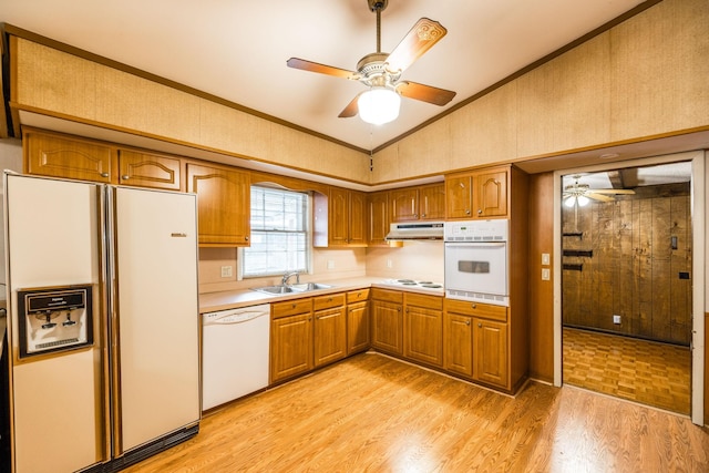 kitchen with under cabinet range hood, vaulted ceiling, white appliances, a ceiling fan, and a sink