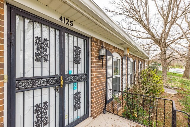 doorway to property featuring brick siding