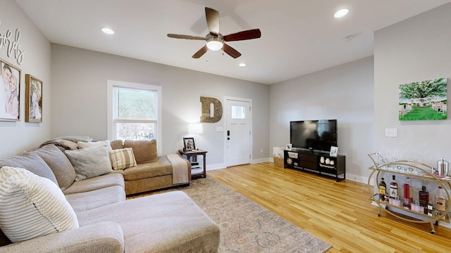 living room featuring recessed lighting, a ceiling fan, light wood-style floors, and baseboards