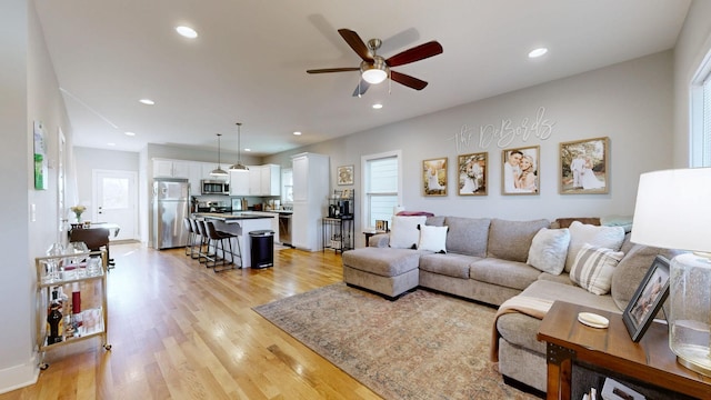 living room with recessed lighting, light wood-style floors, and a ceiling fan
