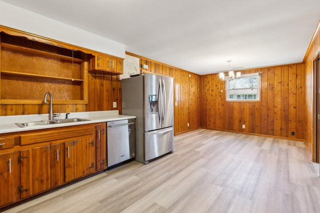 kitchen with brown cabinets, open shelves, a sink, stainless steel appliances, and light wood-type flooring