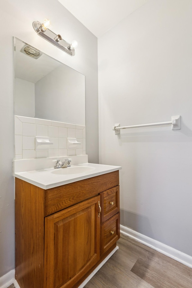 bathroom featuring vanity, baseboards, and wood finished floors