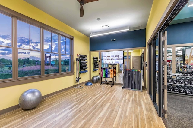 exercise area featuring visible vents, baseboards, ceiling fan, and wood finished floors