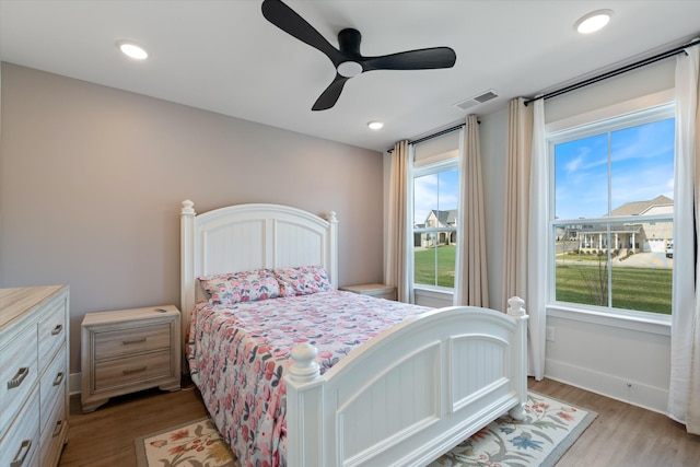 bedroom with a ceiling fan, visible vents, light wood finished floors, baseboards, and recessed lighting