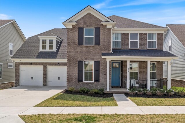 view of front of house with driveway, a porch, roof with shingles, a garage, and brick siding